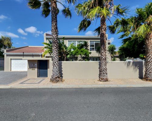 Luxury Beach Holiday Accommodation in Sunset Beach, Cape Town Front exterior of sunset beach house with palm trees in Cape Town luxury holiday accommodation
