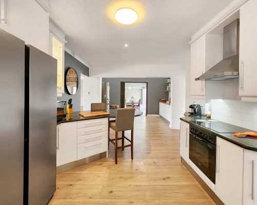 Luxury Beach Holiday Accommodation in Sunset Beach, Cape Town Spacious open plan kitchen with island seating and appliances at sunset beach house luxury holiday accommodation Cape Town