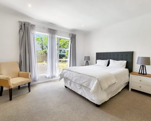 Luxury Beach Holiday Accommodation in Sunset Beach, Cape Town Spacious bedroom with pool and garden view at sunset beach house luxury holiday accommodation Cape Town