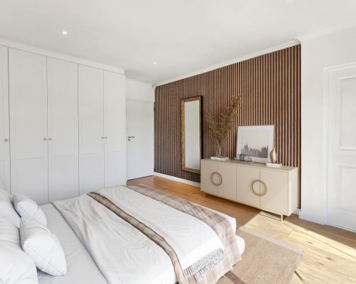 Luxury Beach Holiday Accommodation in Sunset Beach, Cape Town Second bedroom with wooden cladding feature wall and built in wardrobes at sunset beach house luxury holiday accommodation Cape Town