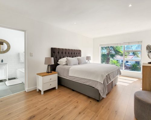 Luxury Beach Holiday Accommodation in Sunset Beach, Cape Town Luxury main bedroom with large bed and natural light at sunset beach house luxury holiday accommodation Cape Town