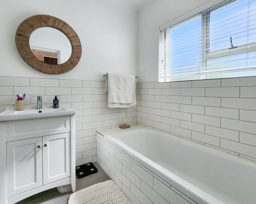 Luxury Beach Holiday Accommodation in Sunset Beach, Cape Town Modern bathroom with bathtub and natural light at sunset beach house luxury holiday accommodation Cape Town